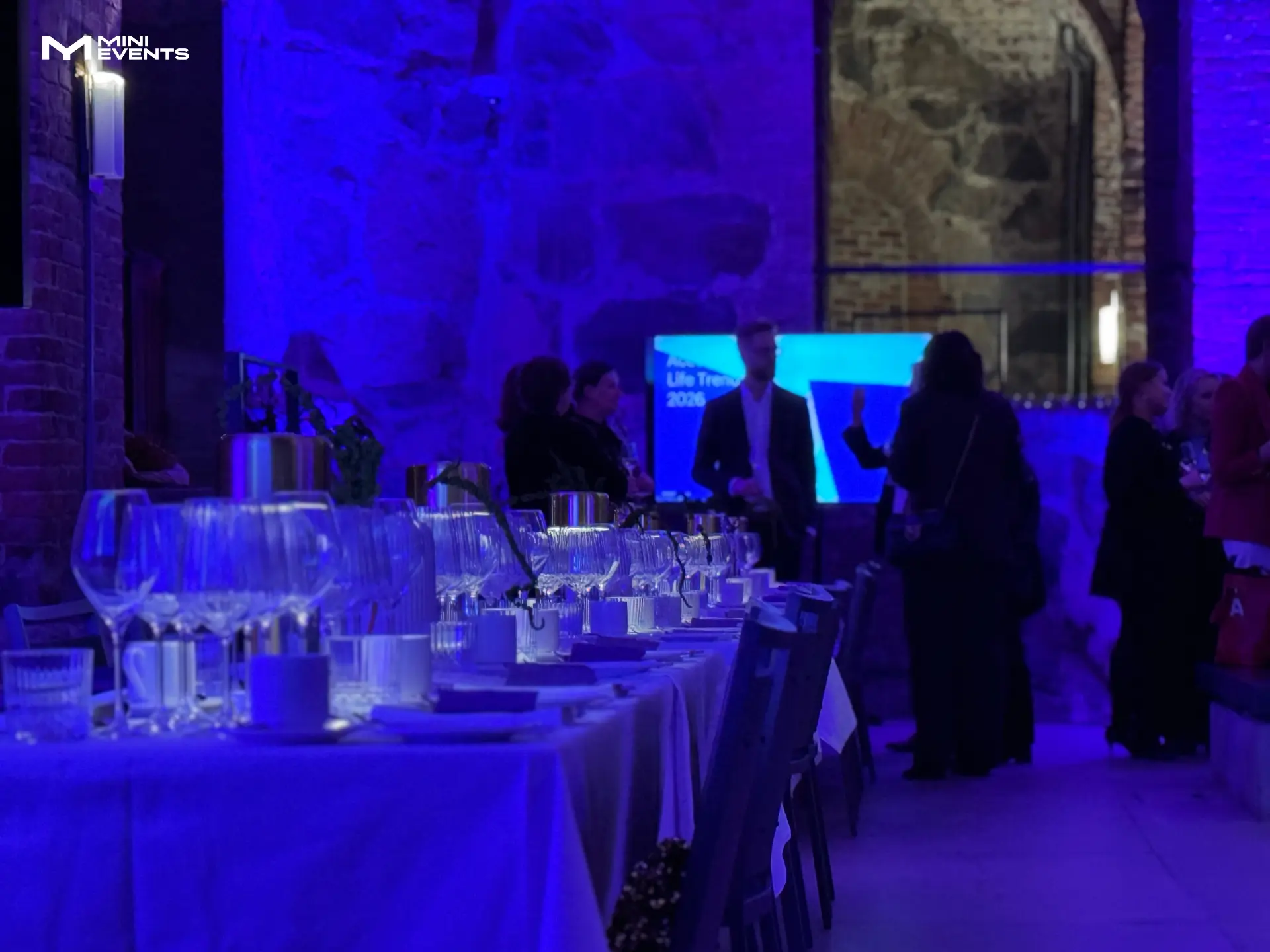 Accenture dinner in the Crypt: set table, guests and blue-lit stone vaults